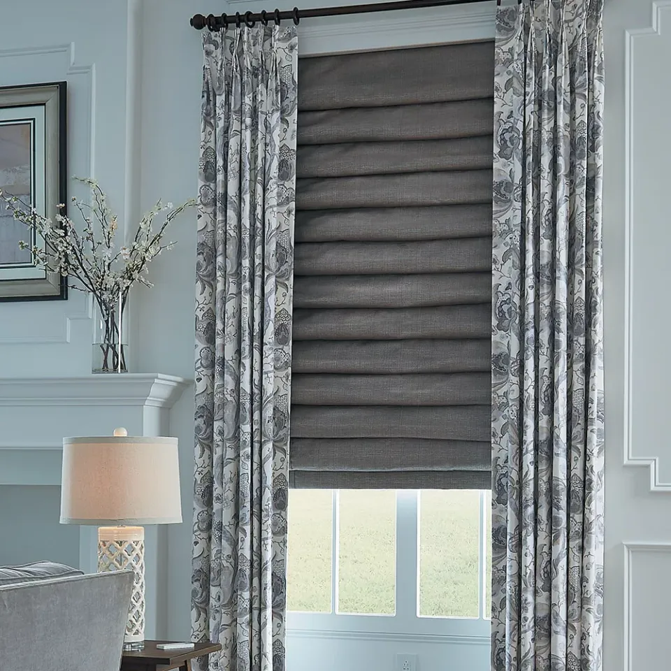 Gray roman shade and floral drapery in a living room