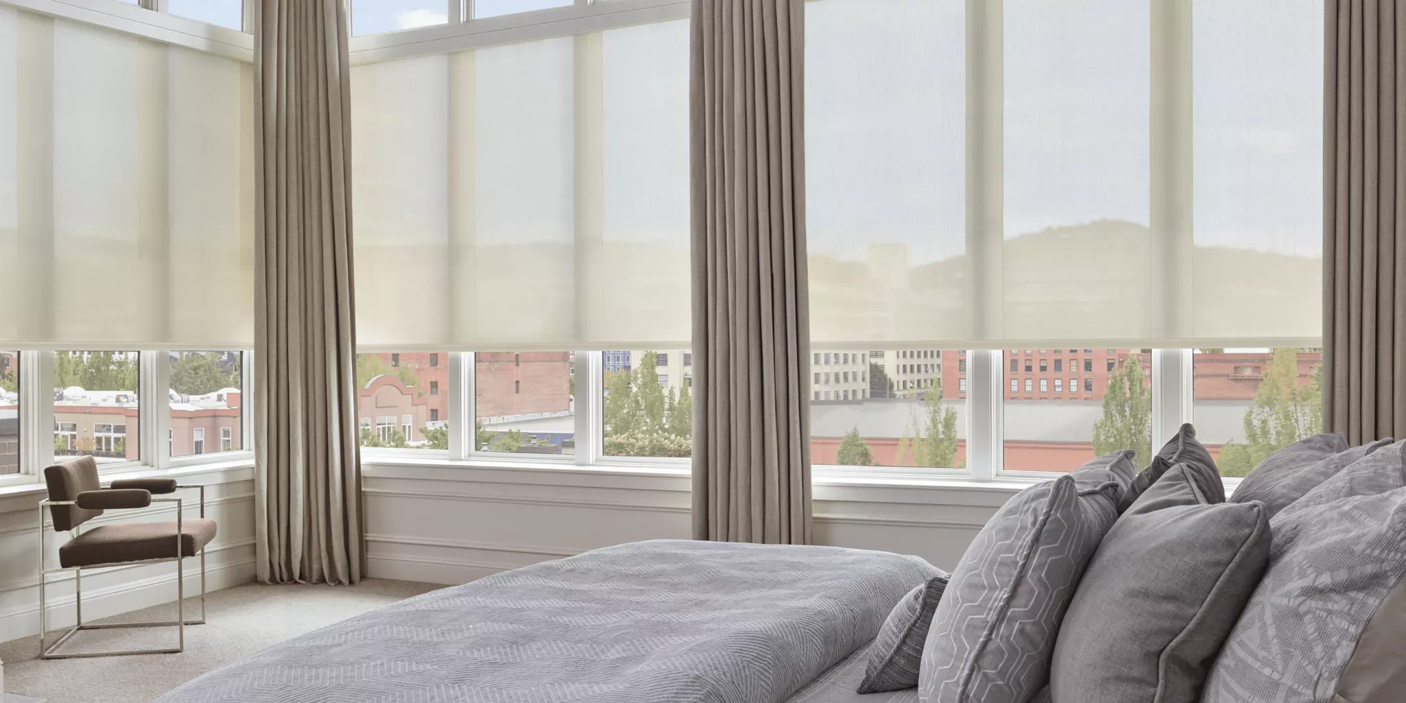 Custom drapery panels layered over roller shades