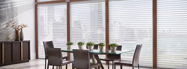 Silhouette window shadings with soft fabric vanes filtering daylight over a dining room